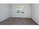 Cozy bedroom with plush carpeting, neutral paint, and a bright window with neighborhood views at 5915 Sw 87Th Ave, Ocala, FL 34481