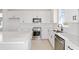 Modern kitchen features sleek white cabinets, stainless steel appliances, and spacious quartz countertops at 5915 Sw 87Th Ave, Ocala, FL 34481