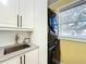 Modern laundry room with white cabinets, black washer and dryer, and window at 6330 Oil Well Rd, Clermont, FL 34714