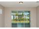 A view through sliding glass doors showcases a well-manicured backyard with lush landscaping at 8707 Sw 57Th Ln, Ocala, FL 34481