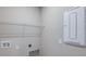 Clean, simple laundry room with ample space for appliances, featuring a wire rack for storage at 8707 Sw 57Th Ln, Ocala, FL 34481