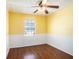 Bright yellow bedroom featuring hardwood floors, a ceiling fan, and chair rail at 5040 Kirkland Rd, Lakeland, FL 33811