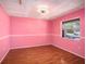Bright pink bedroom with hardwood floors, a ceiling fan, and a bright window at 5040 Kirkland Rd, Lakeland, FL 33811