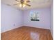 A cozy bedroom with wood-look floors, ceiling fan and a bright window view at 5040 Kirkland Rd, Lakeland, FL 33811