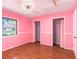 Bright pink bedroom with hardwood floors, two closets, and a bright window at 5040 Kirkland Rd, Lakeland, FL 33811