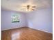 A cozy bedroom with wood-look floors, ceiling fan and a bright window view at 5040 Kirkland Rd, Lakeland, FL 33811
