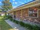 Close-up of a red brick exterior highlighting covered entry with landscaped walkway at 5040 Kirkland Rd, Lakeland, FL 33811