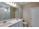 Elegant bathroom featuring double sinks, quartz countertops, and a tiled shower and large mirror at 5329 Sw 81St Cir, Ocala, FL 34481