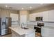 Modern kitchen with white cabinets, a stainless steel microwave, and an island with a sink at 5329 Sw 81St Cir, Ocala, FL 34481