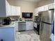 Galley kitchen with stainless steel appliances and white cabinets at 2948 W Cottage Grove Ct # Ge, Orlando, FL 32822