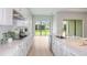 Gourmet kitchen showcases white cabinets, an island, stainless steel appliances, and overlooks the backyard at 5222 Sw 88Th Cir, Ocala, FL 34481