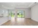 Open concept living room with wood flooring, white walls, and access to the backyard through sliding doors at 5222 Sw 88Th Cir, Ocala, FL 34481