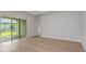 Spacious open-concept living room featuring wood floors and sliders to backyard at 5222 Sw 88Th Cir, Ocala, FL 34481