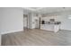 Open concept living space with white cabinets, island, wood flooring and sliding doors to the backyard at 5222 Sw 88Th Cir, Ocala, FL 34481