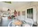 Front porch with wicker furniture, American flag, and glass-top table at 15220 Nw 41St Ter, Reddick, FL 32686