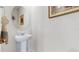Simple bathroom with pedestal sink and round mirror at 1076 Sugarwood St, Davenport, FL 33837