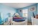 Light blue bedroom with a white bed frame and a window at 1076 Sugarwood St, Davenport, FL 33837