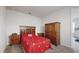 Cozy bedroom with a red comforter and ample closet space at 1076 Sugarwood St, Davenport, FL 33837