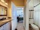 Bathroom with single vanity and toilet, adjacent to bedroom at 164 Sunrise Hill Ln, Auburndale, FL 33823