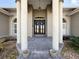 Elegant entryway with columns, double doors, and stone accents at 164 Sunrise Hill Ln, Auburndale, FL 33823