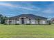 Large one-story home with a stucco exterior, landscaped lawn, and a three-car garage at 164 Sunrise Hill Ln, Auburndale, FL 33823