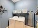 Convenient laundry room with washer, dryer, and storage shelves at 164 Sunrise Hill Ln, Auburndale, FL 33823