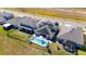 Aerial view of home with solar panels and a pool surrounded by well-maintained landscaping at 3200 Canna Lily Pl, Clermont, FL 34711