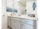 Bright bathroom features a large vanity with a light gray cabinets and a decorative wall art at 3200 Canna Lily Pl, Clermont, FL 34711