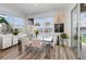 Elegant dining room with a modern glass table, bright windows, and lovely outdoor views at 3200 Canna Lily Pl, Clermont, FL 34711