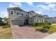 Charming two-story home featuring a brick driveway, well-manicured lawn, and inviting curb appeal at 3200 Canna Lily Pl, Clermont, FL 34711