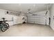 Spacious garage with epoxy flooring, including a refrigerator, shelving, and an automatic garage door opener at 3200 Canna Lily Pl, Clermont, FL 34711