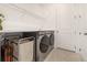 Clean laundry room includes modern washer and dryer, storage shelf, and door to main house at 3200 Canna Lily Pl, Clermont, FL 34711