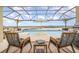 Relaxing outdoor patio area with lounge chairs, a covered seating area, pool, and serene water view at 3200 Canna Lily Pl, Clermont, FL 34711