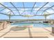 Beautiful screened pool area featuring an umbrella, lounge chairs, and views of the adjacent lake at 3200 Canna Lily Pl, Clermont, FL 34711