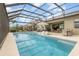 Relaxing screened pool and patio area with comfortable seating, an umbrella, and an outdoor dining space at 3200 Canna Lily Pl, Clermont, FL 34711