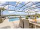 Inviting screened pool area with dining and lounge seating, offering a picturesque view of the lake at 3200 Canna Lily Pl, Clermont, FL 34711