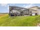 A tranquil screened pool and patio with lush green lawn, comfortable seating, and lake views at 3200 Canna Lily Pl, Clermont, FL 34711