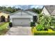 Single-story home with gray garage door and landscaped front yard at 108 La Cresta Ct, Davenport, FL 33837