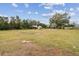 Open backyard area with distant outbuildings at 2028 Marker Rd, Polk City, FL 33868
