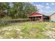 Red barn with attached run and fenced area at 2028 Marker Rd, Polk City, FL 33868