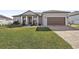 House exterior showcasing a two-car garage and manicured lawn at 7021 Bentridge Dr, Lakeland, FL 33813