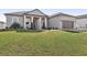 Tan house exterior, two car garage, well-maintained lawn at 7021 Bentridge Dr, Lakeland, FL 33813