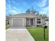 Tan house with gray door, one car garage, and driveway at 1314 W Highland St, Lakeland, FL 33815