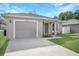 Tan house with gray door, one car garage, and driveway at 1314 W Highland St, Lakeland, FL 33815