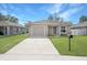 Tan house with gray door, one car garage, and driveway at 1314 W Highland St, Lakeland, FL 33815