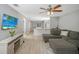 Open living area featuring a sectional sofa, hardwood floors, and a view into the kitchen at 1314 W Highland St, Lakeland, FL 33815