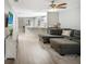 Open living area featuring a sectional sofa, hardwood floors, and a view into the kitchen at 1314 W Highland St, Lakeland, FL 33815