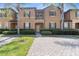 Two-story townhome with palm trees and brick walkway at 225 Cambria Ave, Davenport, FL 33897