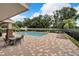 Community pool featuring lounge chairs, tables, and a covered area with privacy fence at 4698 Harts Brook Ln, Mulberry, FL 33860