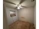 Small bedroom with window unit, ceiling fan, and worn carpet at 1401 Cr 449, Lake Panasoffkee, FL 33538